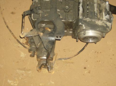 1986 Ford Bronco - This image shows a transfer case, likely from a 4x4 vehicle, with visible linkage and an output shaft.