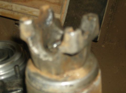 1986 Ford Bronco - Close-up of a metal driveshaft U-joint, showing wear and rust.
