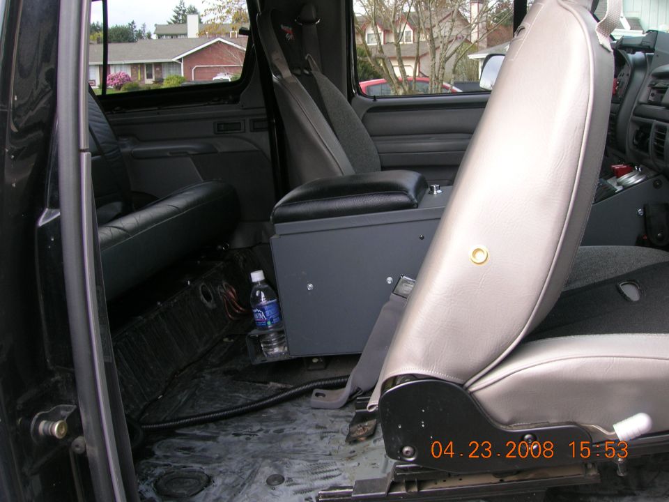 Ford SUV interior with carpet removed, fabricated grey center console and vinyl bucket seat