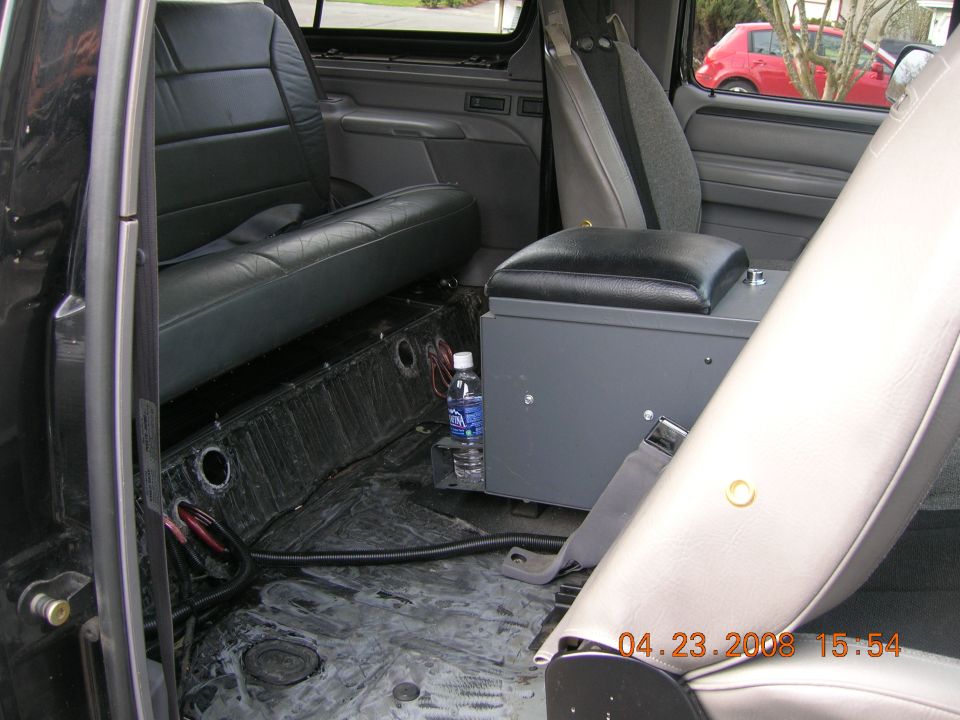 Bronco interior with carpet removed, black rear bench and custom steel center console box