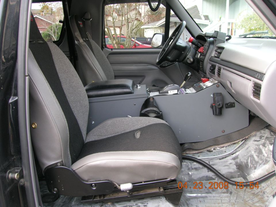 Ford truck interior with cloth buckets and custom gray console full of radios