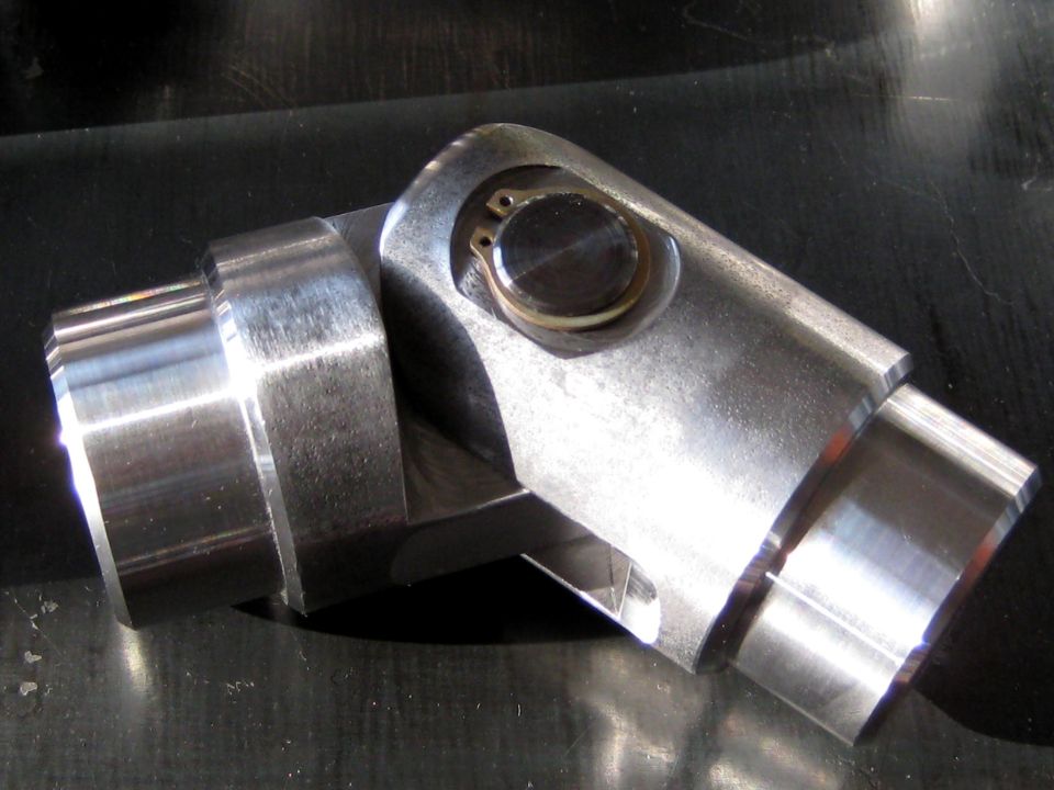 Close-up of a metal universal joint with a visible bearing and clip