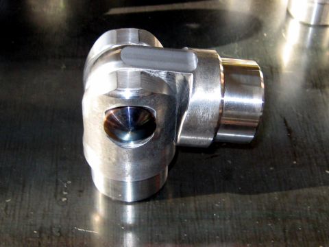 1996 Ford Bronco - A machined metal component, likely a valve, is shown in detail against a dark, reflective surface.