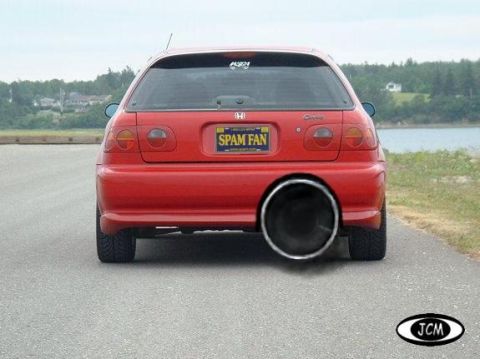 2000 Mercury Grand Marquis - The rear of a red hatchback is shown with a very large exhaust pipe and a custom license plate.
