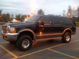 2001 Ford Excursion - Black Ford Excursion SUV with aftermarket wheels parked in a lot at dusk.
