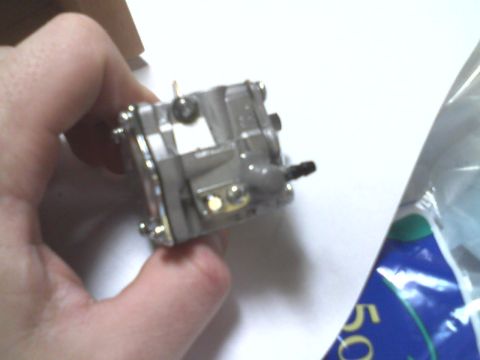 2000 Chevrolet Tahoe - Close-up of a carburetor part held in a hand.