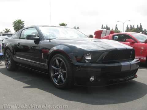 1968 Ford Mustang - A black 2008 Ford Mustang Shelby GT500 is parked next to a red Mustang.