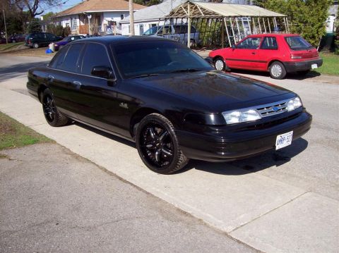 1996 Ford Crown Victoria - This black 1996 Ford Crown Victoria features custom black rims and is parked on a residential street.
