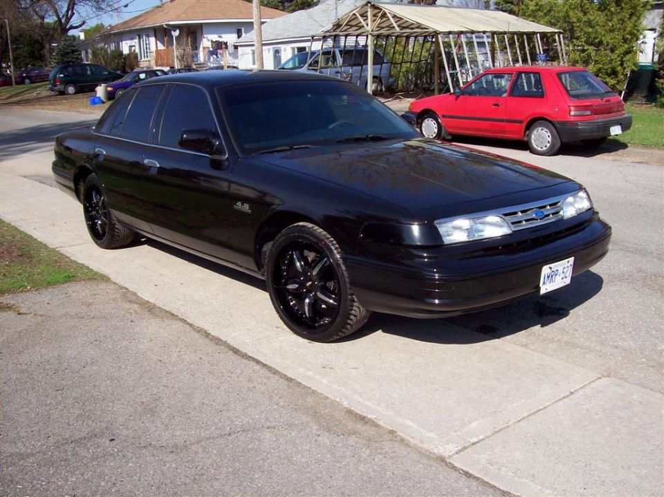 Black 1996 Ford Crown Victoria with custom rims parked on street