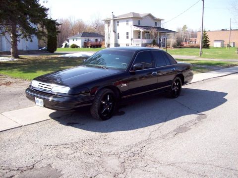 1996 Ford Crown Victoria - This black 1996 Ford Crown Victoria is captured from a 3/4 front angle on a sunny day.