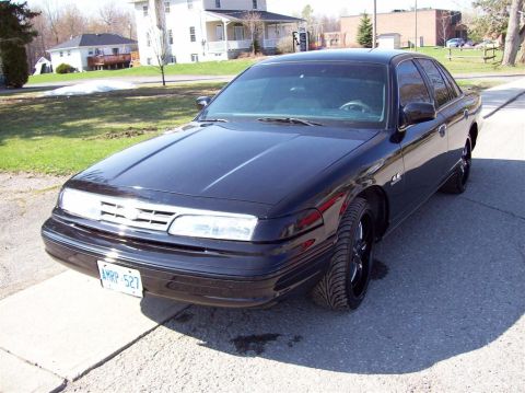 1996 Ford Crown Victoria - This black sedan is parked on a concrete driveway with houses in the background.