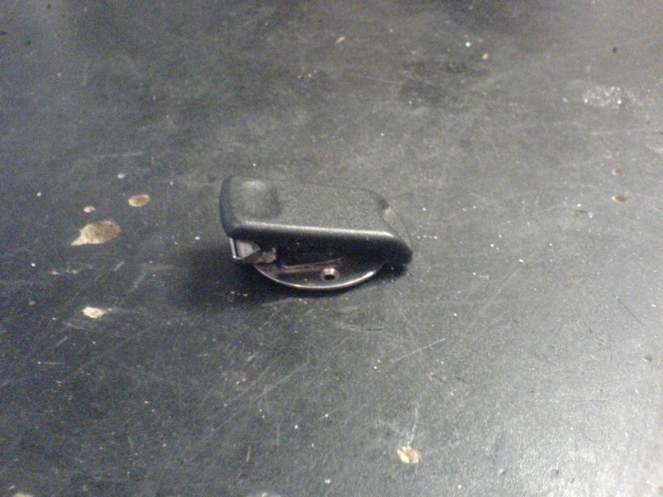 Black plastic part with a metal clip attached to a circular base