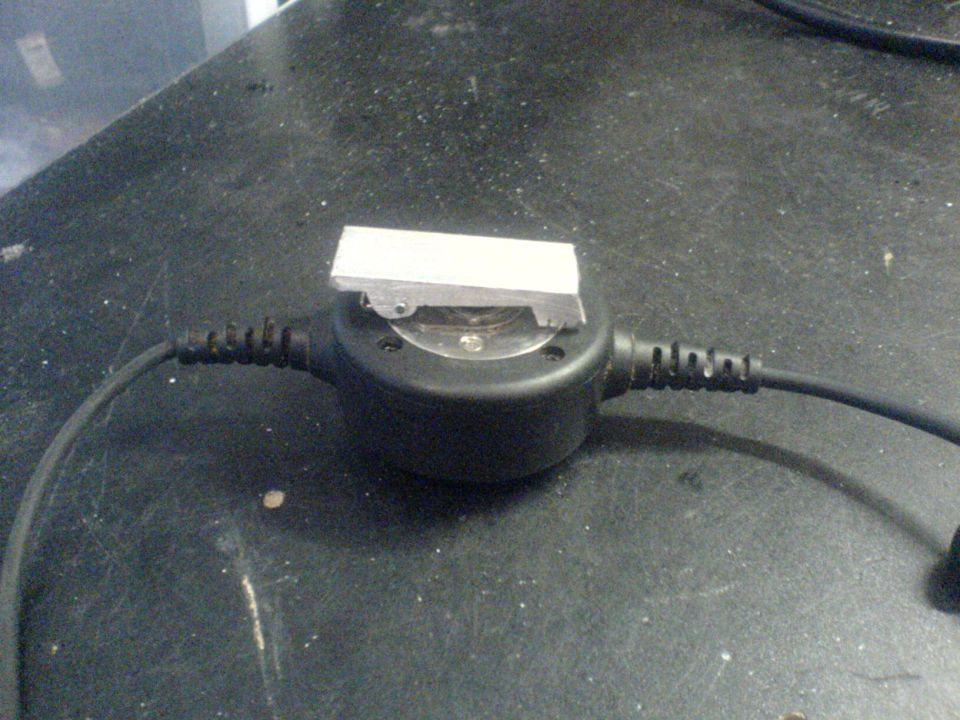 Metal part on black circular device with cables