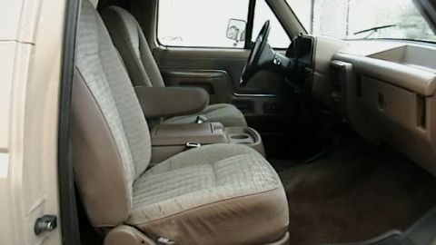 1990 Ford Bronco - The interior of a 1992 Ford Bronco shows tan fabric seats and a dashboard with a center console.