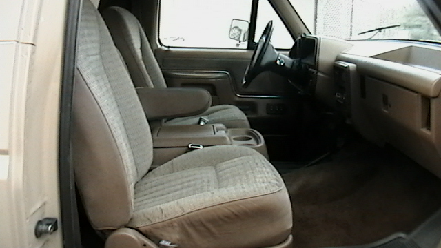 Tan fabric seats and dashboard of a 1992 Ford Bronco interior