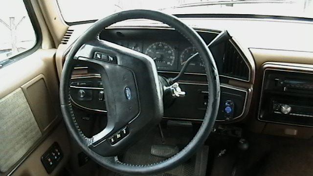 1990 Ford Bronco interior showing steering wheel, dashboard, and radio