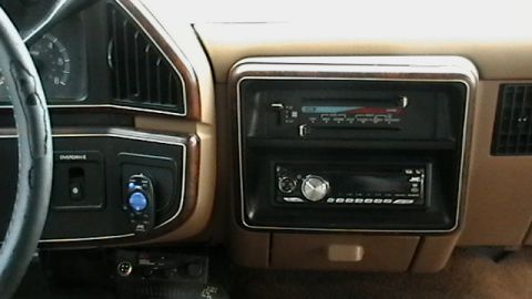 1990 Ford Bronco - The dashboard features a dual-DIN radio setup and wood-grain trim accents.