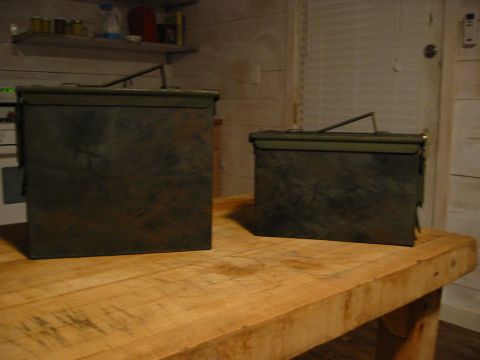 1996 Ford Bronco - Two green ammo cans are placed on a wooden table in front of a wall.