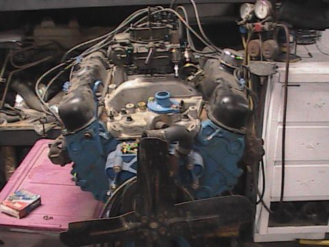1980 Dodge Magnum - Engine assembly with visible carburetor and wiring harness, set against a workshop background.