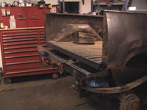 1980 Dodge Magnum - The rear of a truck bed is shown with a red toolbox to the left and a wooden plank floor.