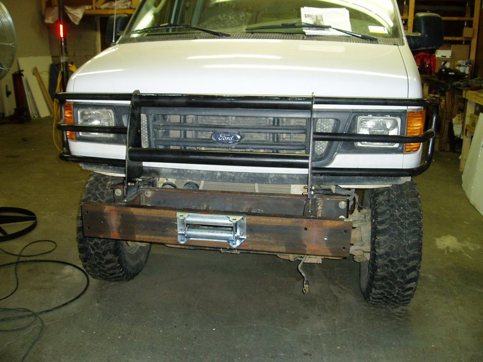 Front view of a 2000 Ford E350 van with a black grille guard and a custom steel bumper with a winch installed