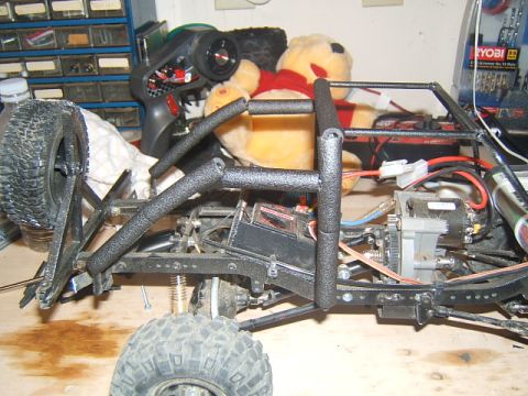 1988 Ford Bronco - Close-up view of an RC crawler's chassis, showing its mechanical components and suspension system.