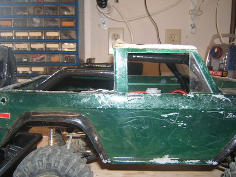 1988 Ford Bronco - Side view of a green RC crawler body showing scuff marks and exposed internal components.
