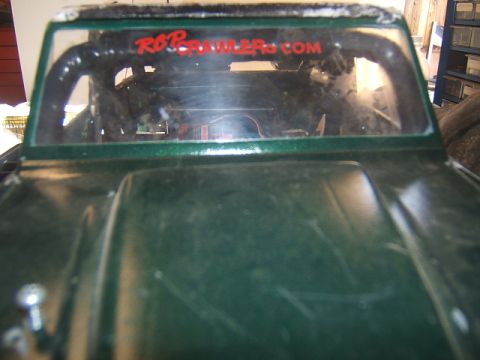 1988 Ford Bronco - Rear view of a green RC crawler, red text on the windshield.