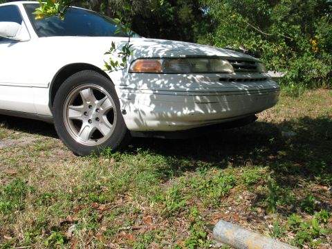 1997 Ford Crown Victoria - A white sedan, likely from the mid-1990s, is parked outdoors with its front end visible.