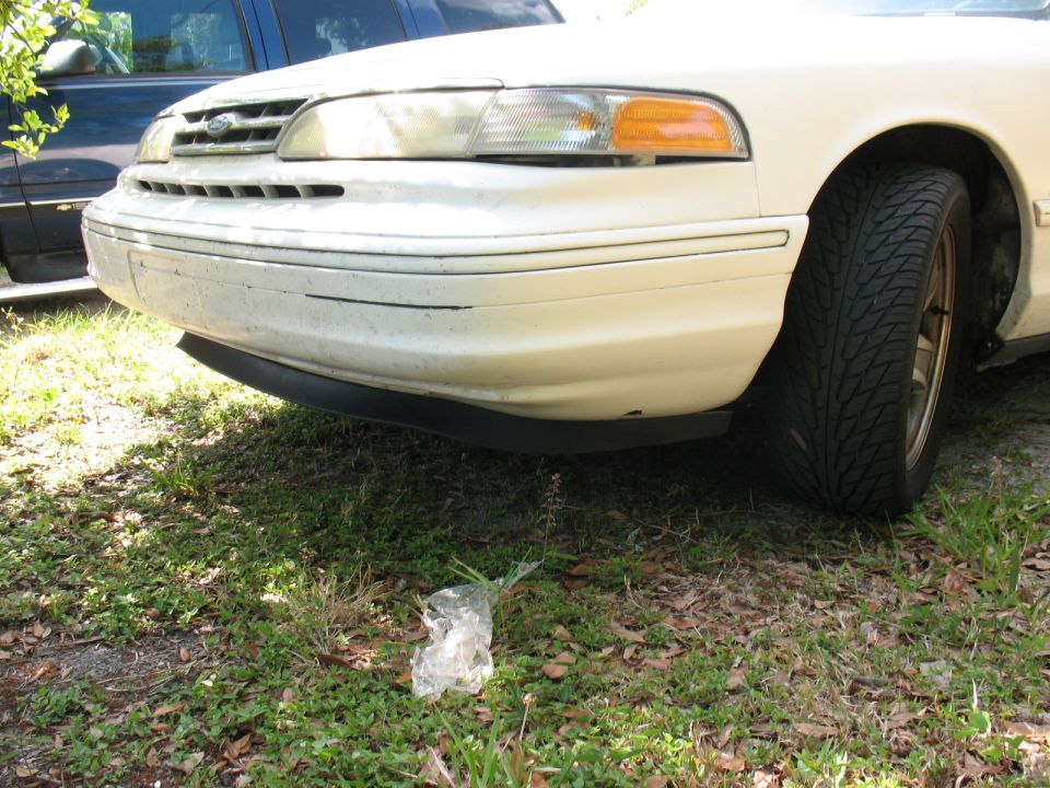 1997 Ford Crown Victoria front bumper with black lower lip and tire visible