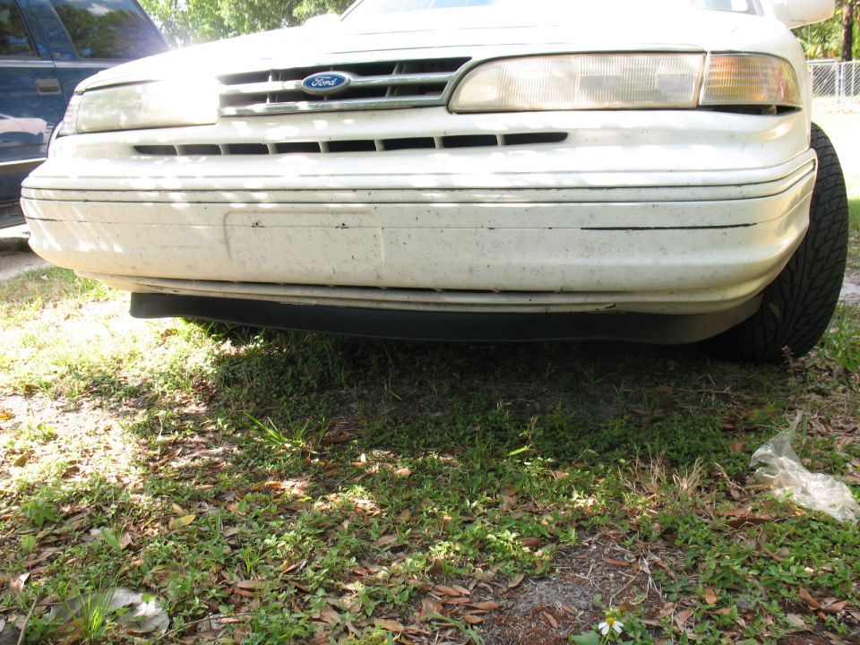 White 1995 Ford Crown Victoria front bumper and grille, with a blue Ford emblem