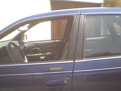 1995 Ford Taurus - The side view of a blue sedan reveals its interior details and a keypad entry system on the driver's door.