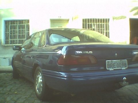 1995 Ford Taurus - Rear view of a dark blue 1995 Ford Taurus sedan, showing the "TAURUS" badging and license plate.