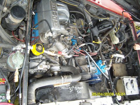 1989 Ford Bronco - Overhead view into the engine bay of a red Ford truck showing a 5.0 EFI V8 with the intake plenum lettering visible, serpentine belt and pu…