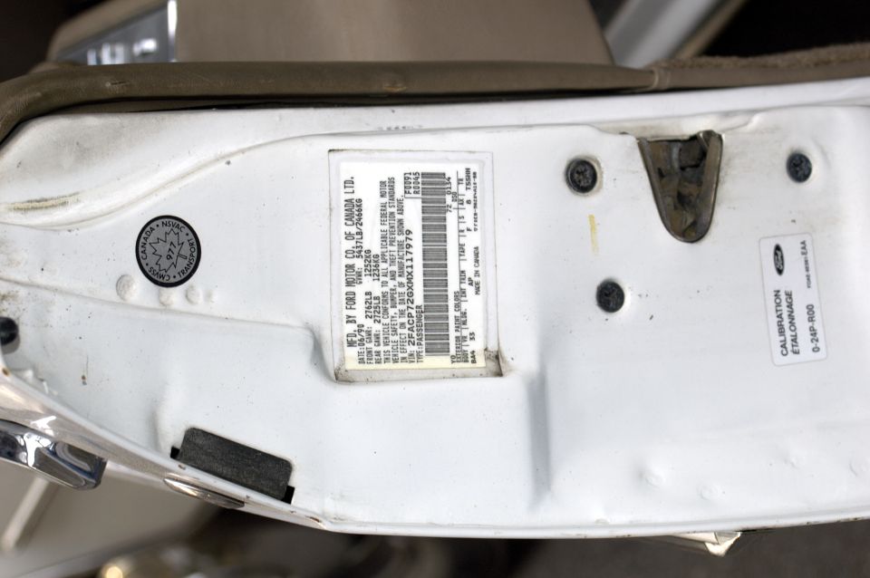 Ford of Canada door jamb certification label with VIN barcode and calibration sticker