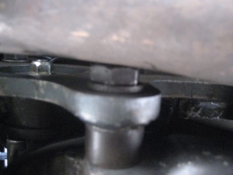 1993 Ford Probe - A close-up view shows a bolt secured to a metal bracket, with other components blurred in the background.