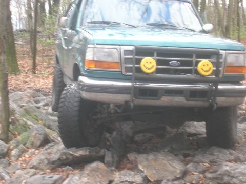 1996 Ford Bronco - 1996 Ford Bronco navigating a rocky trail with its front end visible.