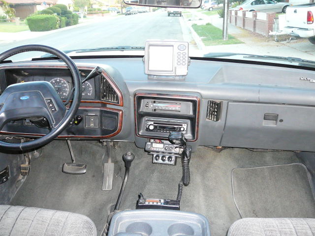 Gray Ford truck dash with wood-trim stereo stack, CB radio, and dash-mounted GPS unit