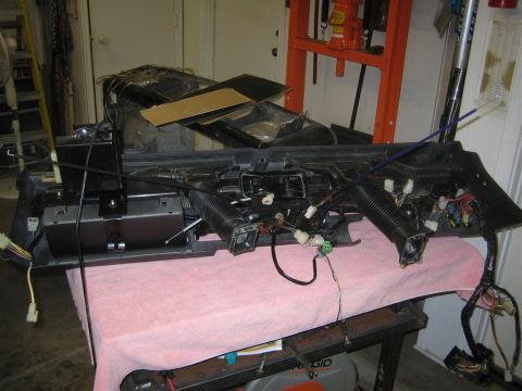 1987 Suzuki Samurai - A disassembled dashboard assembly, showing wiring harnesses and air ducts, is laid out on a table.
