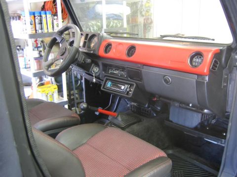1987 Suzuki Samurai - The interior of this vehicle features red dashboard trim, a manual transmission, and an aftermarket stereo system.