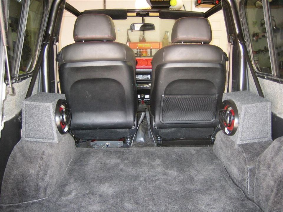 Rear cargo area of SUV with two front seats and subwoofer enclosures