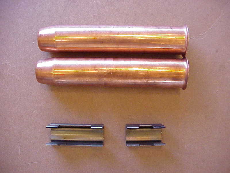 Pair of copper flanged valve guides and two split guide inserts on cardboard