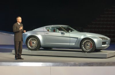 2004 Mercury Messenger - A silver coupe is presented by a man in a suit on a stage.