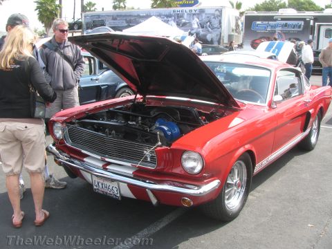 1968 Ford Mustang - A red 1966 Ford Mustang GT is displayed with its hood open, revealing the engine bay.