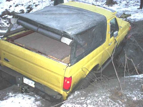 1988 Ford Bronco - This 1988 Ford Bronco is stuck in a muddy ditch with snow on the ground.