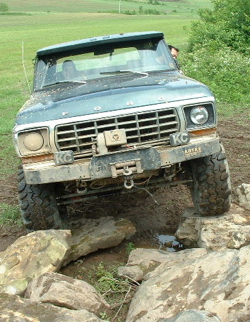 1988 Ford Bronco - This Ford Bronco is navigating a rocky, muddy terrain.