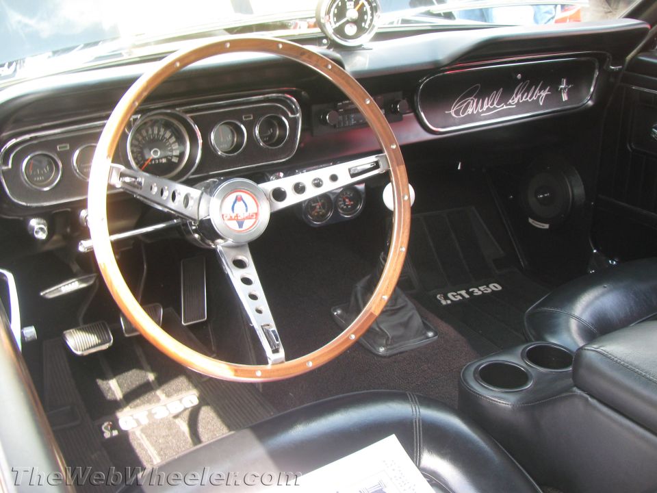 1966 Shelby GT350 interior with wood steering wheel, Shelby Cobra logo, and GT350 floor mats