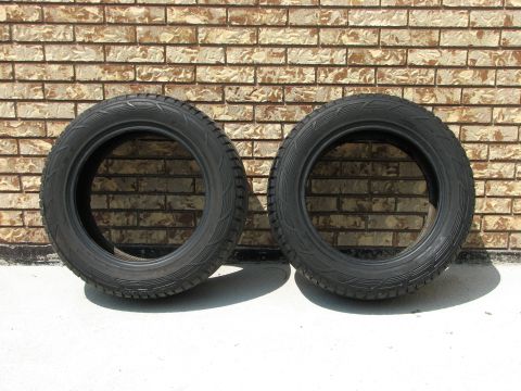 2003 Ford Crown Victoria - A pair of tires are displayed in front of a brick wall, with a Supermotors.net logo in the lower right corner.