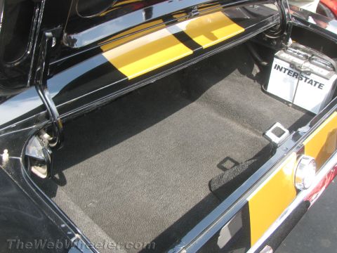 1968 Ford Mustang - The trunk of a 1968 Ford Mustang shows black carpeting and yellow racing stripes.