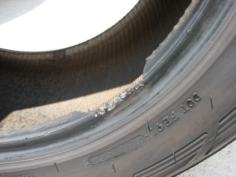 2003 Ford Crown Victoria - Tire sidewall shows significant damage and tearing.